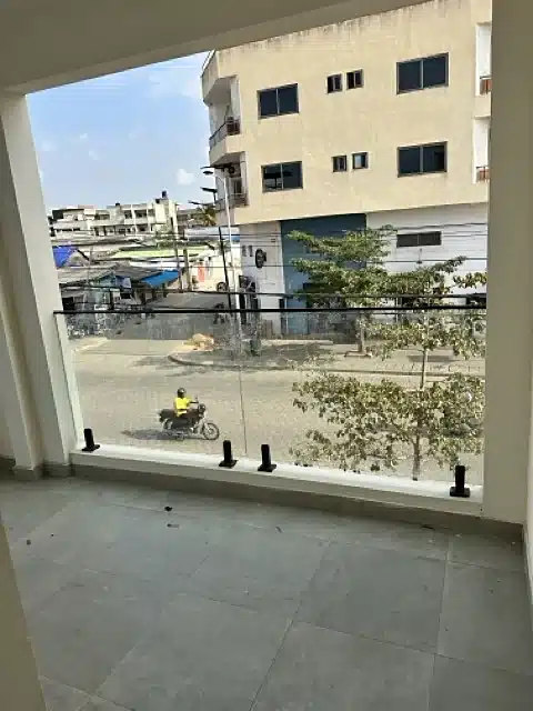 Balcon avec garde-corps vitré donnant sur la rue, appartement à louer à Akogbato
