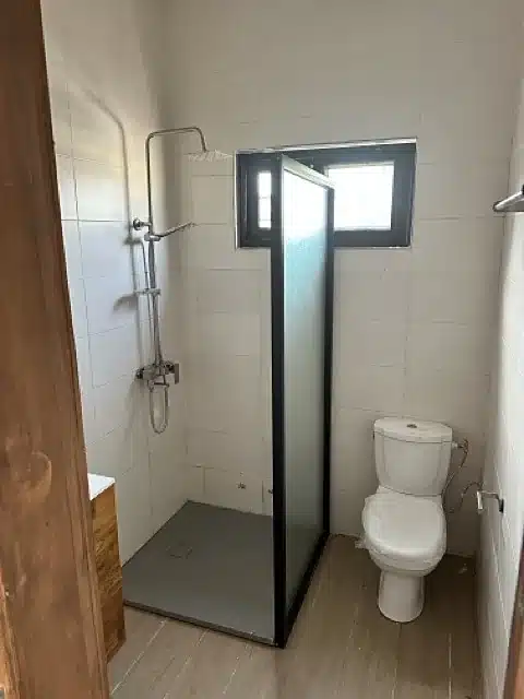Salle d’eau avec douche vitrée et WC, appartement à louer à Akogbato